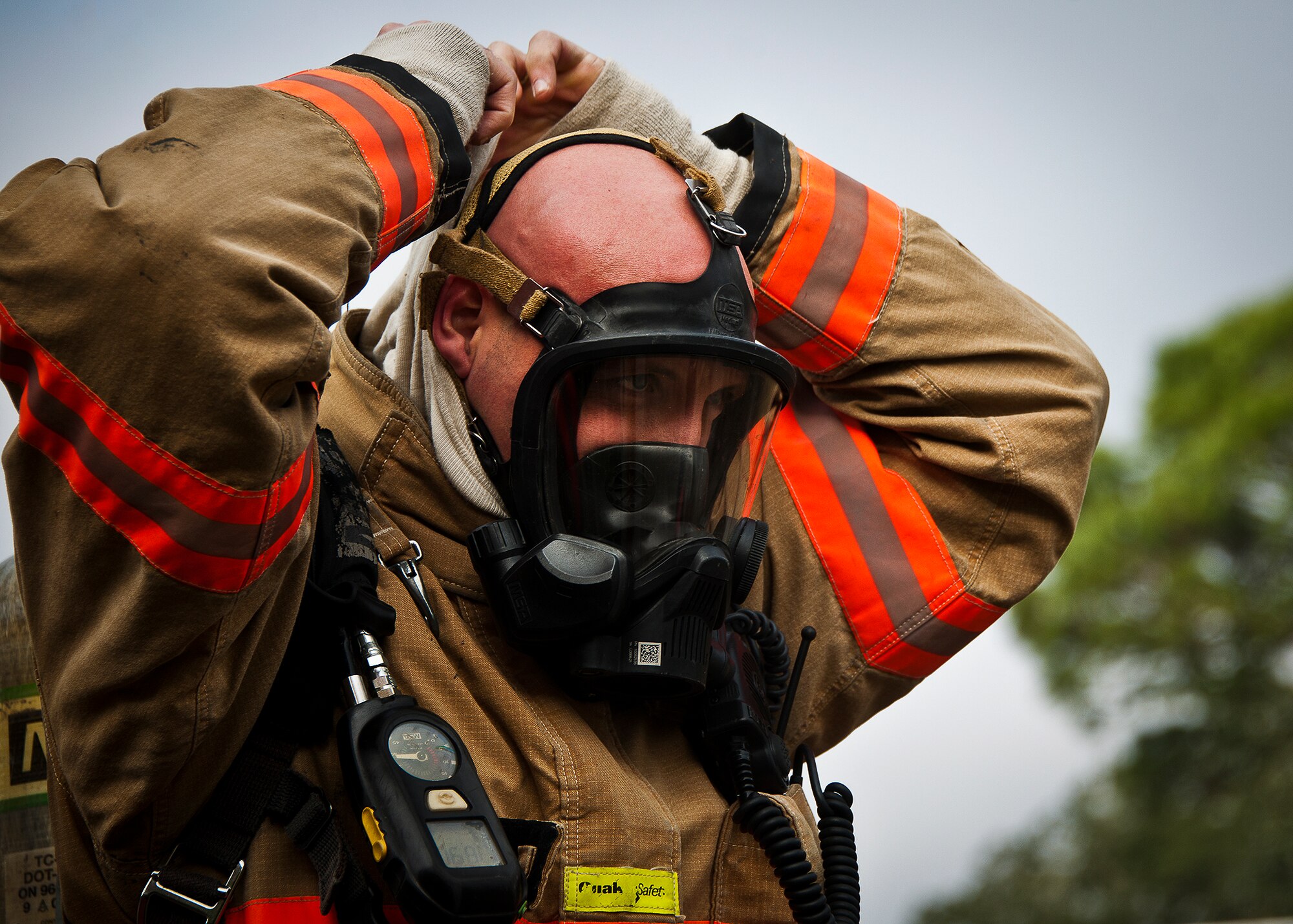 Jerry Carlton, a firefighter with the 96th Civil Engineer Squadron, dons his personal protective equipment prior to  entering the building to begin the structural live-fire training exercise at Eglin Air Force Base, Fla., Dec. 12.  Two-person teams entered a building on fire and demonstrated hose and various firefighting procedures while engaging the controlled blaze.  (U.S. Air Force photo/Samuel King Jr.)