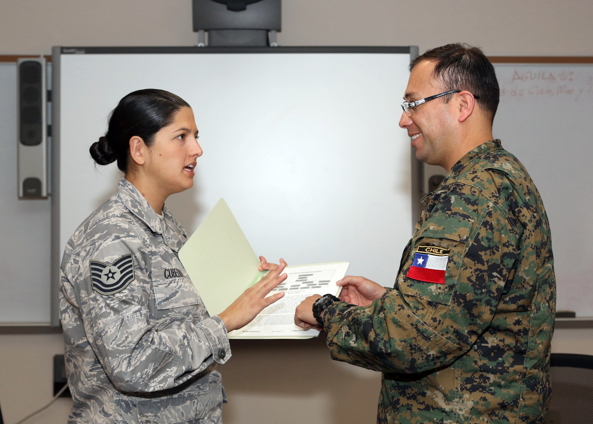 U.S. Air Force Tech. Sgt. Janeth Cubeddu and Chilean Army Sgt. Segundo
Claudio Lopez Ramirez discuss similarities and differences in
hierarchies and structure between U.S. and Chilean military services at the Inter-American Air Forces Academy in Joint Base San Antonio-Lackland, TX, Dec. 5, 2012. (Photo by Robin Creswell)
