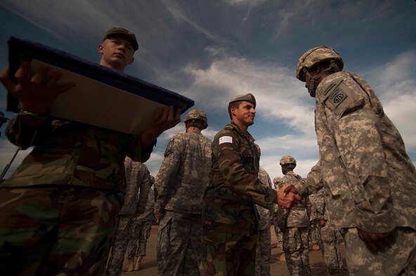 Uruguayan Army Sgt. Eduardo Olivares, awards Urauguayan jump wings to  a U.S. Army paratrooper   during Operation Toy Drop 2012 at Fort Bragg, N.C. 2012 marks the 15th year for the Randy Oler Memorial Operation Toy Drop which collects toy donations for children and families in need and gives paratroopers the opportunity to jump with foreign jumpmasters. Soldiers donate a new toy in exchange to jump with a foreign jumpmaster and earn foreign jump wings. This year, OTD has expanded from its traditional focus around Fort Bragg, NC to select cities around the country. OTD is a Fort Bragg airborne tradition. Operation Toy Drop combines thousands of toys, Army paratroopers, hundreds of volunteers, dozens of allied military personnel, and more than a dozen Air Force aircraft, all for what has become the world's largest combined airborne operation. (U.S. Air Force Photo by Master Sgt. Adrian Cadiz)