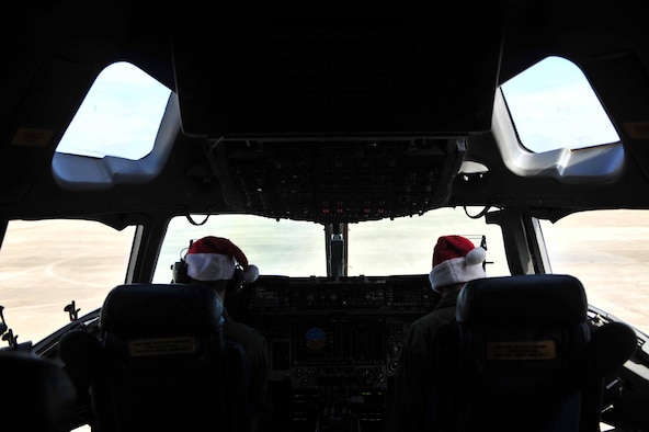 U.S. Air Force C-17 Globemaster III pilots prep their jet while wearing Santa hats before takeoff in support of the Randy Oler Memorial Operation Toy Drop on Fort Bragg, N.C., December 8, 2012. 2012 marks the 15th year for the Randy Oler Memorial Operation Toy Drop which collects toy donations for children and families in need and gives paratroopers the opportunity to jump with foreign jumpmasters. Soldiers donate a new toy in exchange to jump with a foreign jumpmaster and earn foreign jump wings. This year, OTD has expanded from its traditional focus around Fort Bragg, N.C. to select cities around the country. OTD is a Fort Bragg airborne tradition. Operation Toy Drop combines thousands of toys, Army paratroopers, hundreds of volunteers, dozens of allied military personnel, and more than a dozen Air Force aircraft, all for what has become the world's largest combined airborne operation. (U.S. Air Force photo by Senior Airman Matthew J. Bruch)