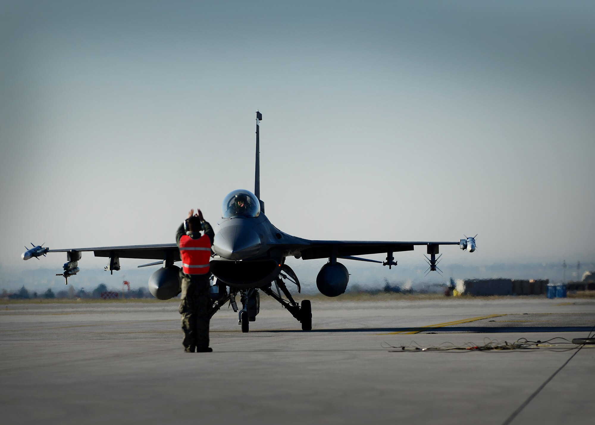 An Airman from the 31st Aircraft Maintenance Squadron marshals an F-16 Fighting Falcon for refueling Dec. 12 at Aviano Air Base, Italy.  The 31st AMXS Airmen plan and direct expeditionary aircraft generation and maintenance operations, and maintain two F-16 Fighting Falcon flying squadrons in support of the 31st Fighter Wing’s flying mission. (U.S. Air Force photo/Staff Sgt. Evelyn Chavez)