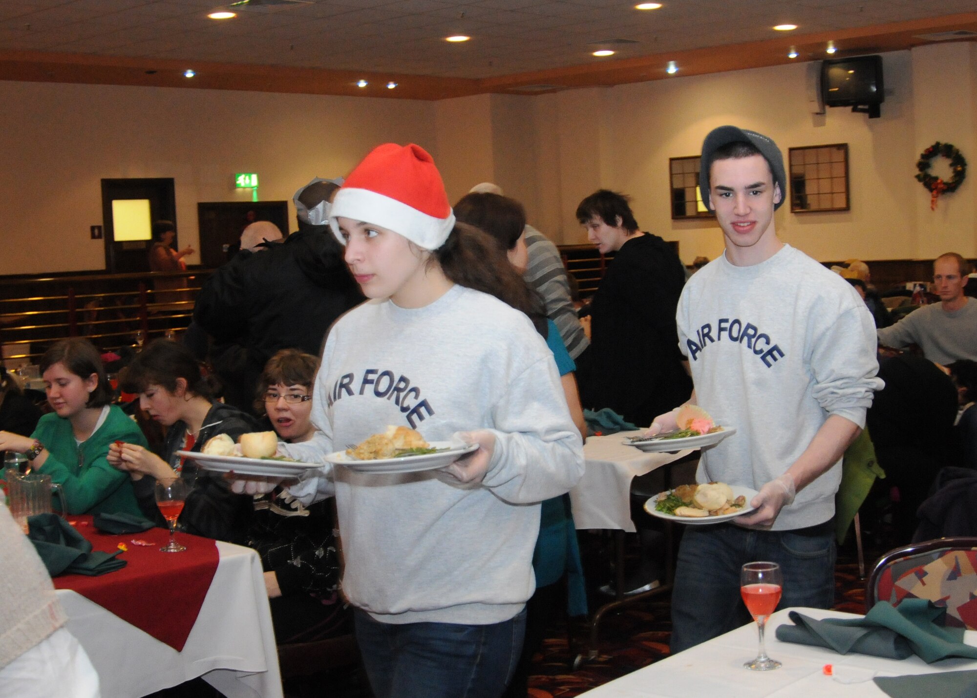 Arriana Lemieux and Dustin Lavender, both cadets with RAF Lakenheath High School's Reserve Officers’ Training Corps, volunteer as servers during the Air Force Sergeants Association Special Needs Christmas Party Dec. 15, 2012, at RAF Mildenhall, England. The event was held for individuals with special needs from both on and off base. (U.S. Air Force photo by Tech. Sgt. Neal X. Joiner/Released)