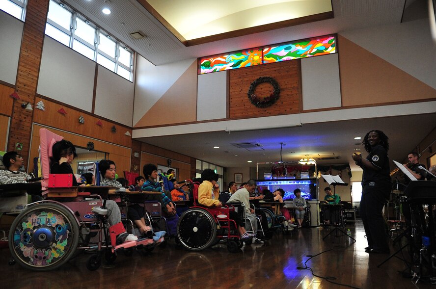 Tech. Sgt. Amber Grimes, a vocalist with the United States Air Force Band of the Pacific-Asia, sings Christmas carols as the band plays along during a performance at the Okinawa Pediatric Development Center in Okinawa, Japan, Dec. 14, 2012. The children were excited to hear the music and even played along with their own instruments during the performance. (U.S. Air Force photo/Staff Sgt. Alesia D. Goosic)