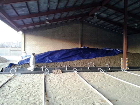 A nearly complete Biopile build-up at K-16 Airfield.  A biopile system uses naturally occurring, living organisms such as plants, bacteria, or fungi to break down hazardous substances. The basic biopile system includes a treatment bed, an aeration system, an irrigation/nutrient system and a leachate collection system. 