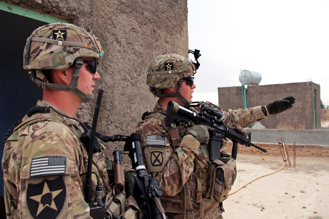 U.S. Army Spc. Michael Landers points out a landmark to U.S. Army Spc. Eric Saum, left, during a leadership meeting in Farah, Afghanistan, Dec. 15, 2012. Landers and Saum are assigned Provincial Reconstruction Team Farah.