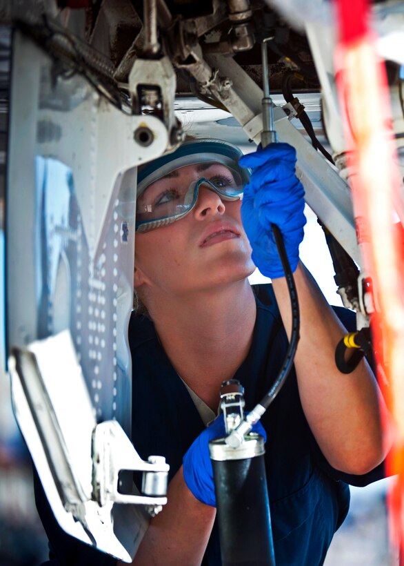Air Force Senior Airman Chelsea Mays applies lubrication to an F-15 Eagle during a mission employment phase exercise on Nellis Air Force Base, Nev., Dec. 7, 2012. Mays, a crew chief, is assigned to the 926th Aircraft Maintenance Squadron.