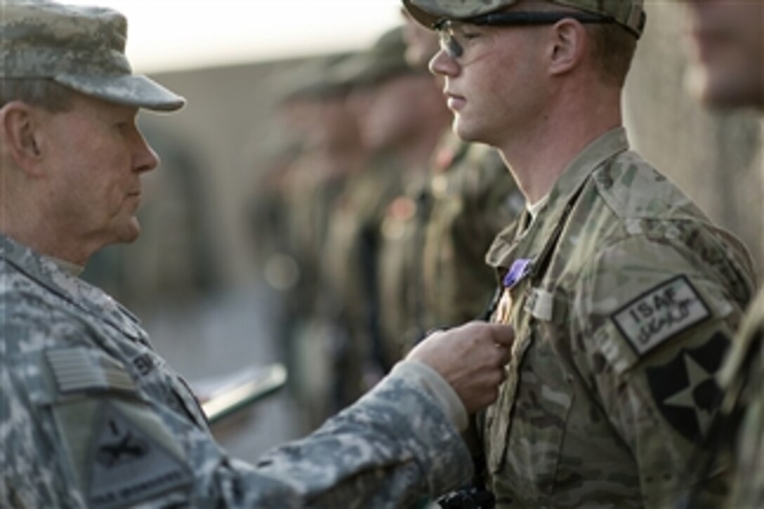 Chairman of the Joint Chiefs of Staff Gen. Martin E. Dempsey, left, awards a Purple Heart to a soldier at Forward Operating Base Azim Jan Karez, Afghanistan, on Dec. 16, 2012.  