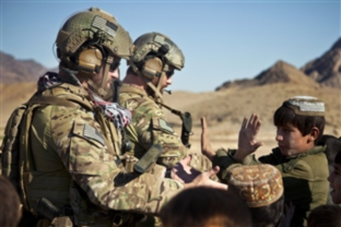 Coalition force members receive high fives from children in a village in Farah province, Afghanistan, Dec. 11, 2012.