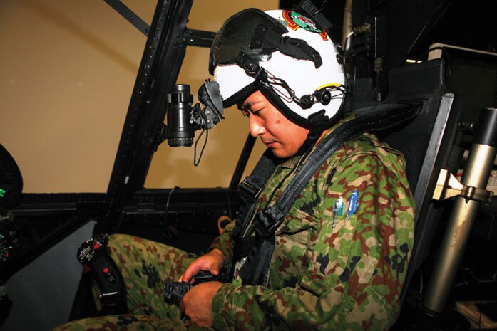 2nd Lt. Ikunari Kashiwagi straps himself into a CH-46E Sea Knight helicopter simulator at Marine Corps Air Station Futenma Dec. 5 during a Japan Observer Exchange Program event. Kashiwagi is a helicopter pilot with 1st Headquarters Brigade, 102 Aviation Unit, JGSDF. Photo by Pfc. Kasey Peacock
