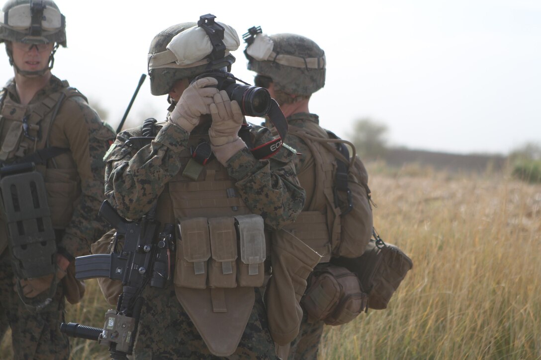 Lance Cpl. Robert Walters, combat photographer, 3rd Battalion, 9th Marine Regiment, Regimental Combat Team 7, takes a photograph while on a patrol through the battalion’s area of operations, Nov. 11, 2012. Walters broke his elbow a year and a half before he joined the Marine Corps and refused to let it hinder him as a Marine.