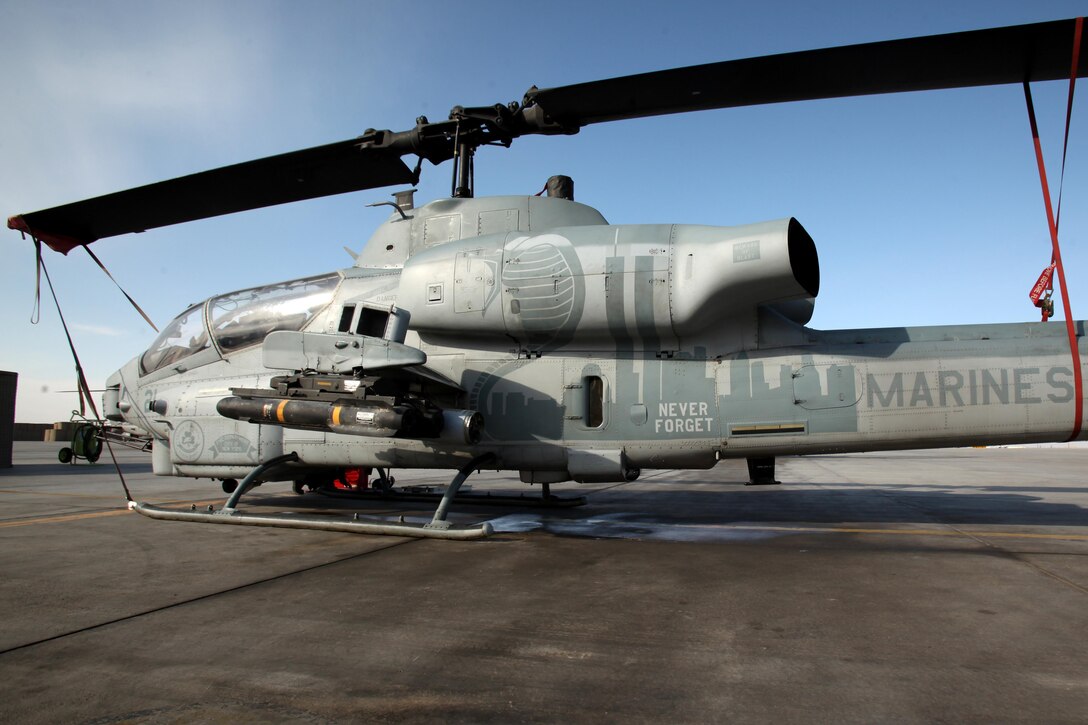 An AH-1W Super Cobra with Marine Light Attack Helicopter Squadron 169 sits on the Camp Bastion, Afghanistan, flightline, Dec. 15, 2012. The squadron’s corrosion control section hand painted a mural on the side of the Super Cobra to help remind the squadron’s Marines and all servicemembers who see the aircraft of why they are deployed.