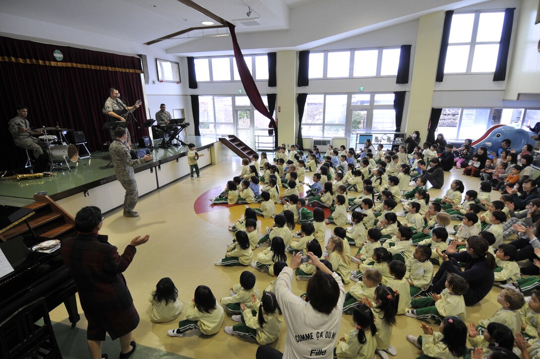 MISAWA, Japan -- The USAF Band of the Pacific-Asia jazz combo enlists the help of a child playing the tambourine at a performance at the Misawa Municipal First Preschool, Misawa, Japan on Dec. 11, 2012.  The group was able to adapt their show to entertain audiences of any age.  (US Air Force Photo/Tech. Sgt. Phillip Butterfield)