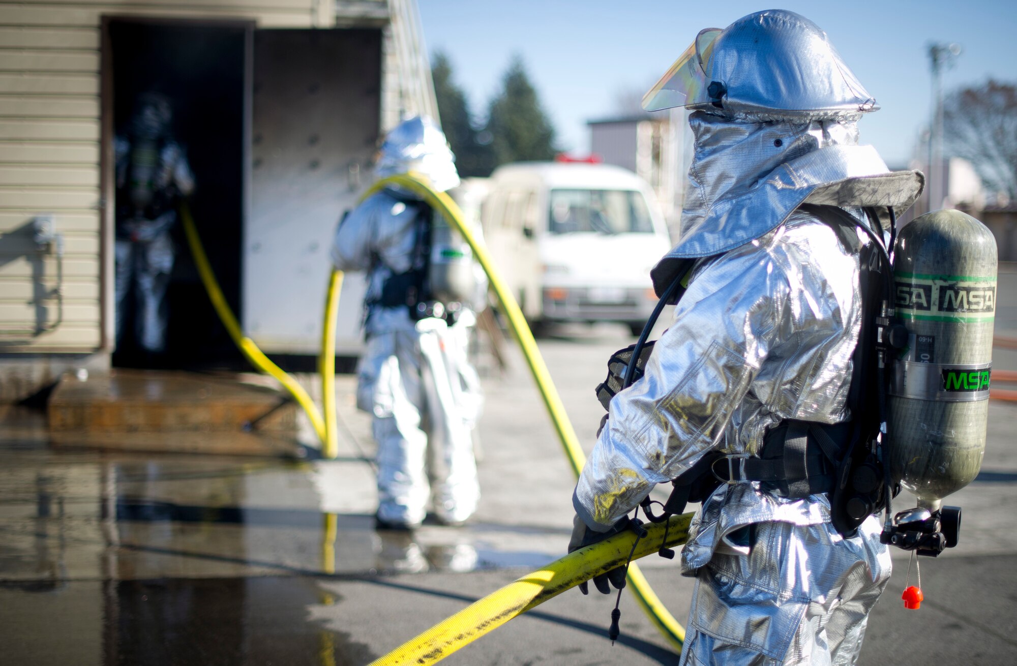 YOKOTA AIR BASE, Japan-- Firefighters from the 374th Civil Engineer Squadron at Yokota Air Base, Japan, hold a water hose for fellow firefighters during a structural burn training exercise on Dec. 13, 2012. One hundred pounds of pressure fill the lines that firefighters handle to put out fires. (U.S. Air Force photo by Staff Sgt. Stacy Moless)