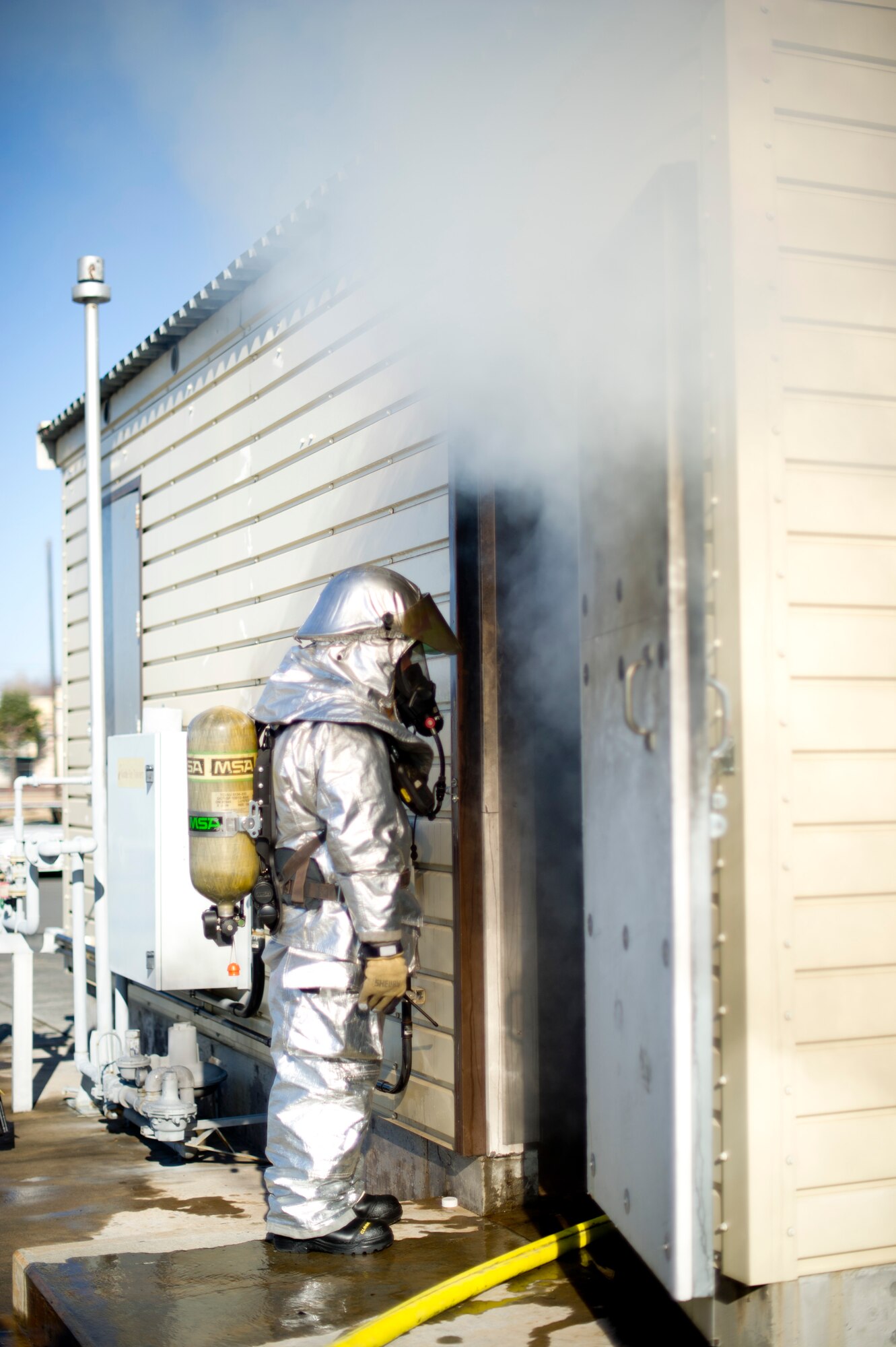 YOKOTA AIR BASE, Japan-- A firefighter from the 374th Civil Engineer Squadron at Yokota Air Base, Japan, monitors fellow firefighters during a structural burn training exercise on Dec. 13, 2012. The firefighters use propane to saturate wooden crates then set them on fire inside a building. (U.S. Air Force photo by Staff Sgt. Stacy Moless)