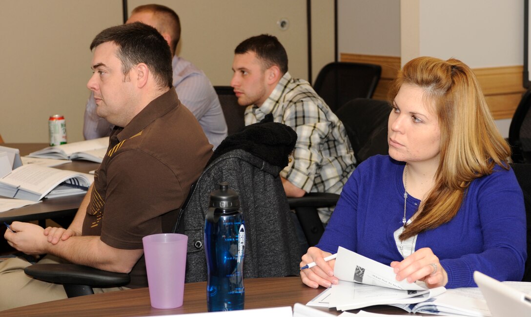 Staff Sgt. Karleigh Moss, 28th Comptroller Squadron financial analyst (right), listens to a Transition Assistance Program instructor talk about effective resume writing during a TAP class in the Airman and Family Readiness Center at Ellsworth Air Force Base, S.D., Dec. 13, 2012. The four-day class is required for Airmen who are separating and optional for retiring Airmen to help prepare them for different career, financial and educational situations as they prepare to move into civilian life. (U.S. Air Force photo by Airman Ashley J. Woolridge/Released) 