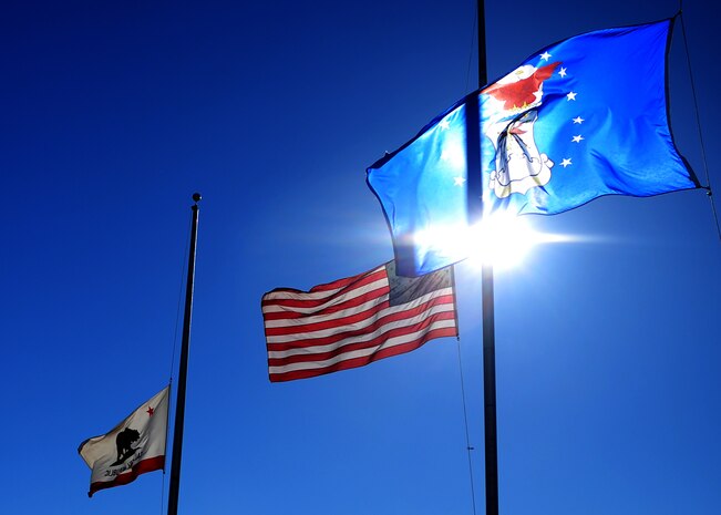 Flags fly at half-staff behind the SR-71 Black Bird static display at Heritage Park at Beale Air Force Base, Calif., Dec. 18, 2012. The flags will be at half-staff until Dec. 18, 2012, in honor of slain students from Sandy Hook Elementary School, Conn. (U.S. Air Force photo by Senior Airman Shawn Nickel/Released)
