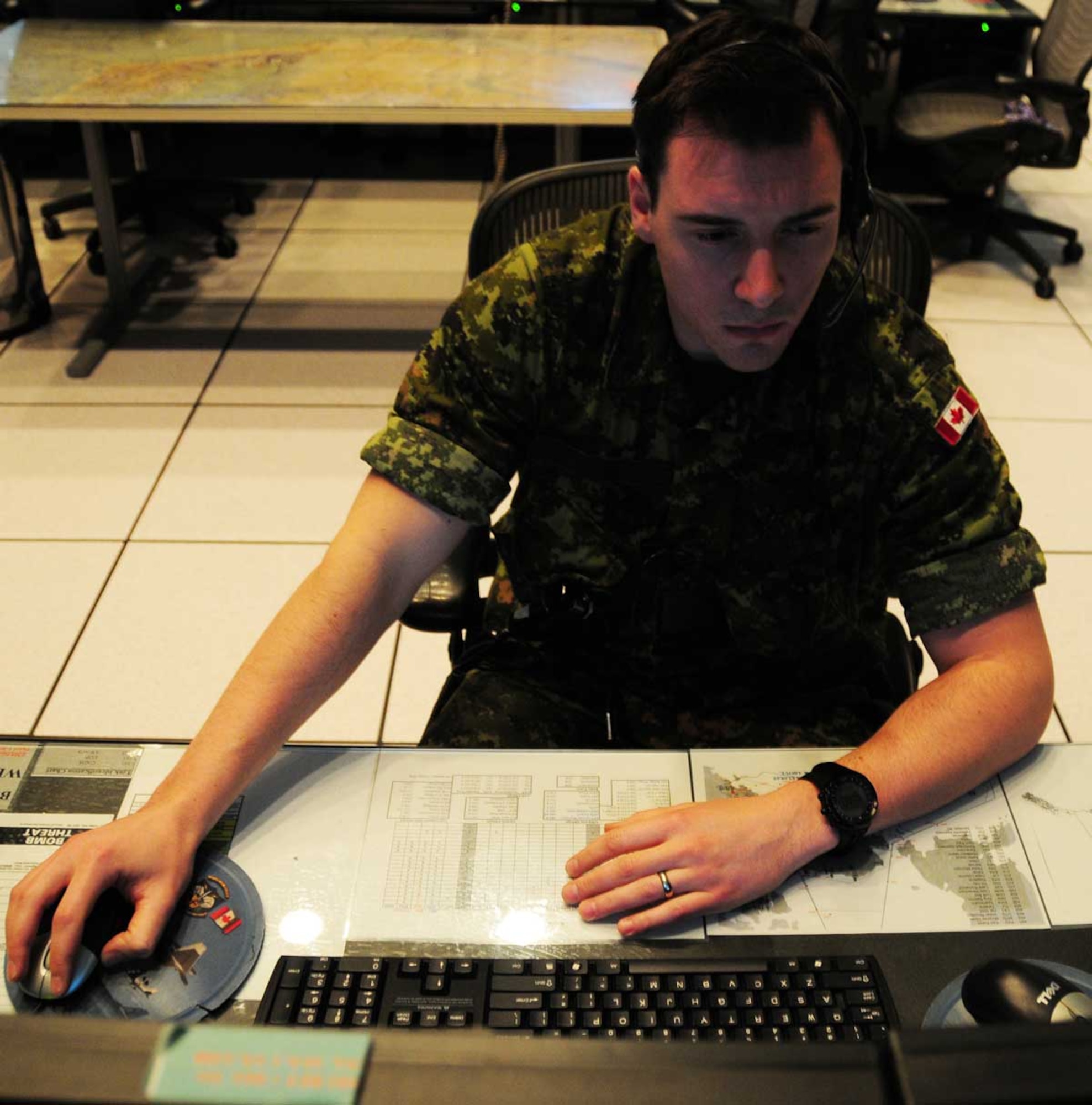 JOINT BASE ELMENDORF-RICHARDSON, Alaska -- Royal Canadian Air Force Capt. Christopher Schenk, an air weapons officer in the Alaskan NORAD Region Regional Air Operations Center (RAOC) and Toronto native, monitors Alaskan airspace on the same radar scope he'll use to track Santa's flight Christmas Eve. Children of all ages interested in tracking Santa can do so at www.noradsanta.org, visit the NORAD Tracks Santa Facebook page at www.facebook.com/noradsanta, follow Santa’s progress on Twitter by subscribing to @NoradSanta, or track Santa via mobile phone by downloading the free NORAD Tracks Santa app. (U.S. Air Force photo/Master Sgt. Mikal Canfield)