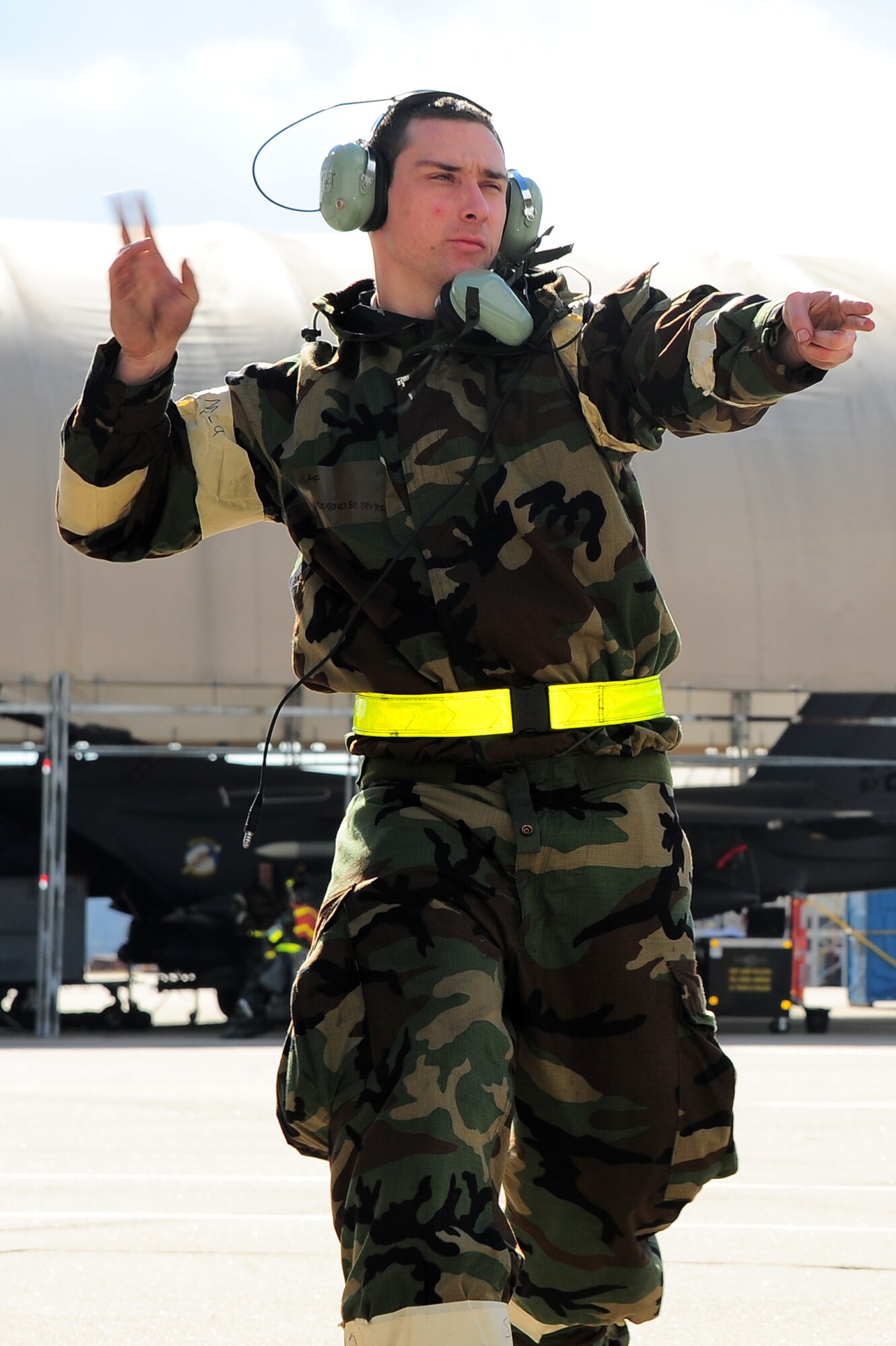 U.S. Air Force Senior Airman Destin St. Peter, 333rd Aircraft Maintenance Unit crew chief, signals for an aircraft to taxi onto the flight line during Operational Readiness Exercise Coronet Warrior 12-06 on Seymour Johnson Air Force Base, N.C., Dec. 18, 2012. Maintenance personnel continued to simulate aircraft deployment during fluctuating force protection conditions and mission oriented protective postures. (U.S. Air Force photo/Airman 1st Class Aubrey White/Released)
