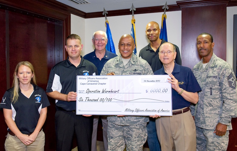 Ernie Joy, second from right, President of the Military Officers Association of America, Cape Canaveral Chapter, and Senior Master Sgt. Galen Zalace, 45th Civil Engineer Squadron, second from left, present a $6,000 check in support of Operation Warmheart to Brig. Gen. Anthony Cotton, commander, 45th Space Wing. Also pictured (left to right) are Master Sgt. Rebecca Ewertz, 333rd Recruiting Squadron, Courtney Yelle, First Vice-President, MOAA, Master Sgt. Michael Wynne, 45th Security Forces Squadron and Chief Master Sgt. Herman Moyer, 45th Space Wing command chief. Every year around the holidays, MOAA donates money to Operation Warm Heart. It helps military members from all the different branches assigned to Patrick Air Force Base and Cape Canaveral Air Force Station.