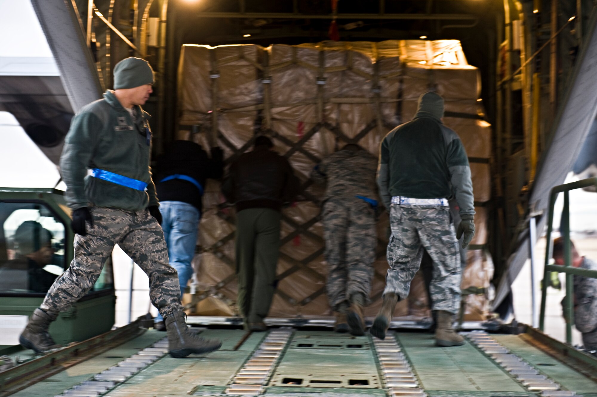 BUCKLEY AIR FORCE BASE, Colo. – Col. Robert Uemura, 460th Mission Support Group commander; Maj. John Gustafson, 460th Logistics Readiness Squadron commander; and 460th LRS members load a C-130J Hercules from the 317th Airlift Group, Dyess Air Force Base, Texas, Dec. 14, 2012, on the Buckley flightline. The aircraft was loaded with more than 17,000 pounds of household goods, clothing, shoes, hospital beds and crutches donated by Isabellas Little Miracles LLC, Casper, Wyo. (U.S. Air Force photo by Airman 1st Class Riley Johnson)