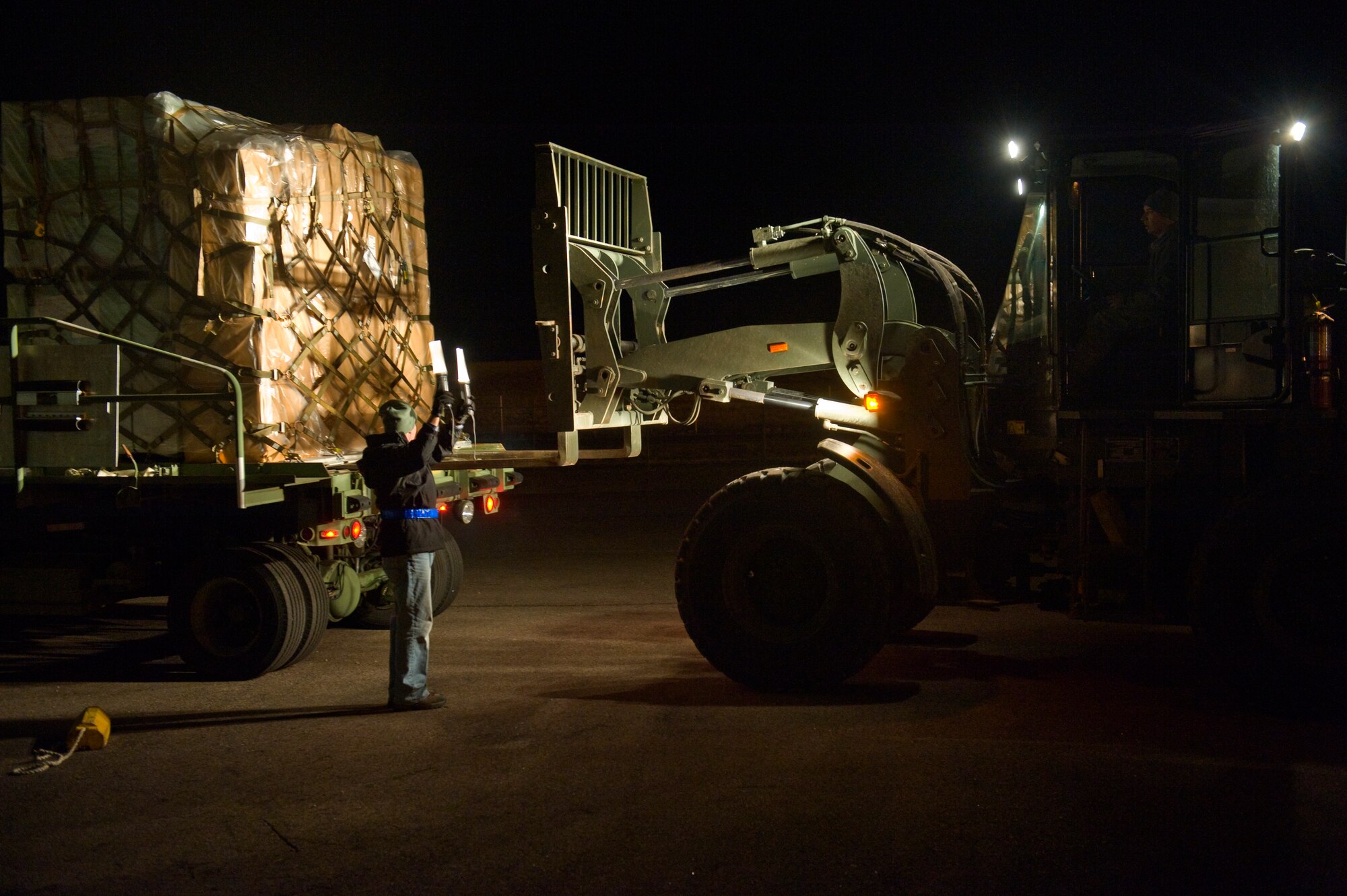 BUCKLEY AIR FORCE BASE, Colo. – Christopher Henriques, 460th Logistics Readiness Squadron, directs Staff Sgt. Steven Bouquet, 460th LRS, while loading a pallet of humanitarian supplies Dec. 14, 2012, at the 460th LRS building. More than 17,000 pounds of household goods, medical supplies and equipment was loaded onto C-130J Hercules from the 317th Airlift Group, Dyess Air Force Base, Texas. (U.S. Air Force photo by Airman 1st Class Riley Johnson)