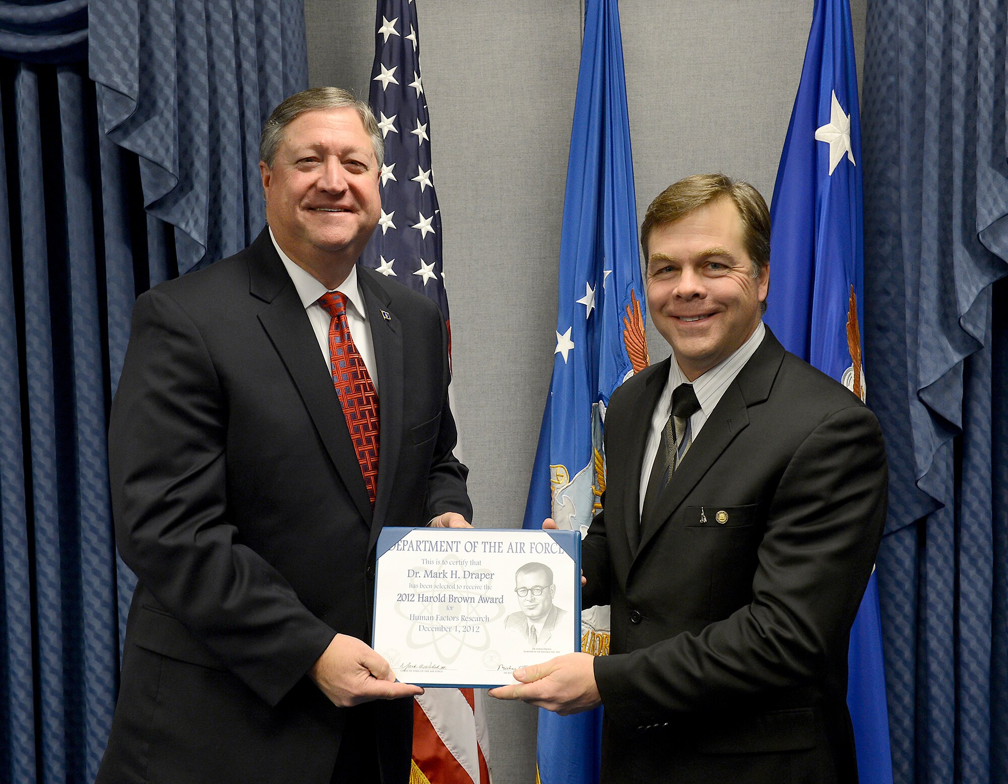 Secretary of the Air Force Michael Donley presents the 2012 Harold Brown Award to Dr. Mark Draper during a Pentagon ceremony Dec. 17, 2012. Donley presented Draper the award for his significant achievement in research and development. As a leader and international authority on user interfaces and supervisory control optimization for remotely piloted aircraft, Draper's accomplishments have been directed at improvements to RPA operator interfaces and future warfighting capabilities. Draper is a senior engineering research psychologist with the Air Force Research Laboratory's 711th Human Performance Wing at Wright-Patterson Air Force Base, Ohio. (U.S. Air Force photo/Scott M. Ash)