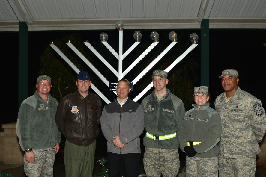 U.S. Air Force Col. Clay Hall, 20th Fighter Wing commander (second from left) and Chief Master Sgt. James Wilkerson 20th Fighter Wing command chief, join several of the Shaw chapel members in a group photo for the menorah lighting ceremony, Shaw Air Force Base, S.C. Dec.12, 2012. This event was the first menorah lighting ceremony held on Shaw. A menorah is a candelabrum used in jewish worship. In certain cases there are either seven or nine branches. (U.S. Air Force photo by Airman 1st Class Ashley L. Gardner/ Released)