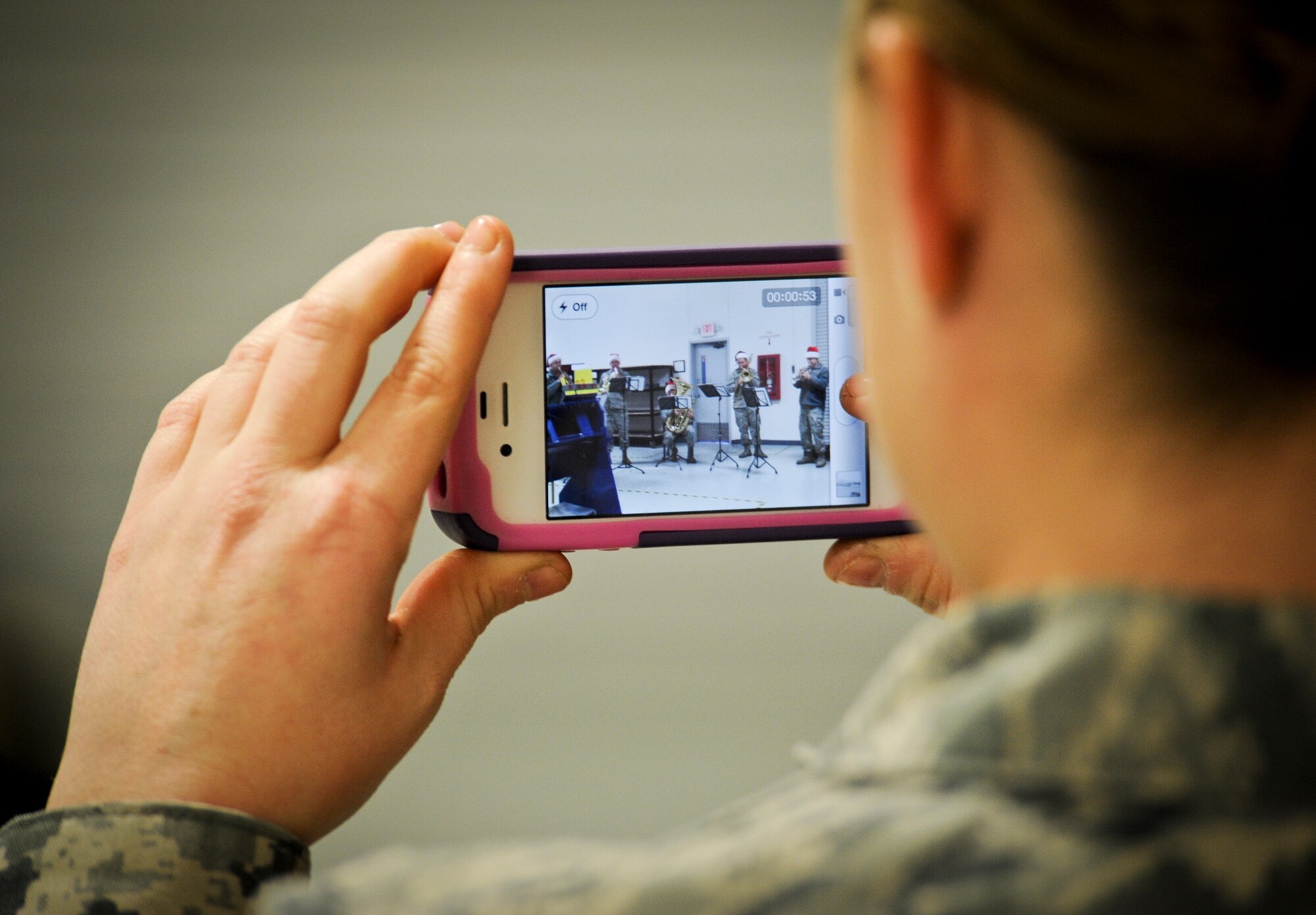 Staff Sgt. Samantha Burton records the Golden West Brass Quintet from Travis Air Force Base, Calif., with her smart phone as they play holiday carols for members of the 92nd Maintenance Squadron’s sheet metal flight during the band’s visit to Fairchild Air Force Base, Wash., Dec. 14, 2012. The band also played for the surrounding community. (U.S. Air Force photo by Senior Airman Benjamin Stratton)