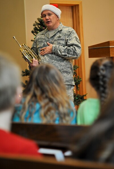 Tech. Sgt. Tom Hanrahan talks with students and faculty of St. Matthew Lutheran School in Spokane, Wash., Dec. 13, 2012. Hanrahan is a French horn player with the Golden West Brass Quintet that visited Fairchild and the surrounding community Dec. 13 and 14. The technical sergeant is originally from Salt Lake City. (U.S. Air Force photo by Senior Airman Benjamin Stratton)