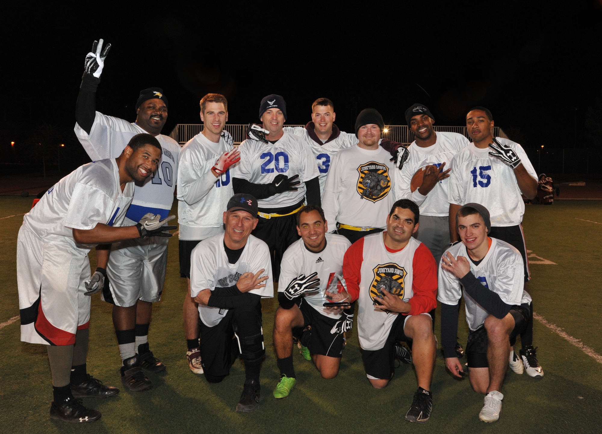 GOODFELLOW AIR FORCE BASE, Texas- The Junk Yard Dogs pose with their championship trophy, won in the Flag Football Intramural Championship game at the football field here, Dec. 12. The team defeated The Combats with a final score of 33-13. (U.S. Air Force photo/ Airman 1st Class Erica Rodriguez)