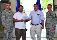 Flanked by (from left)  Lt. Gen. Eric Fiel, commander of  Air Force Special Operations Command,  and Chief Master Sgt.  William Turner, AFSOC’s command chief,  Lazaro Martin, left, and Tommy Vinson display the 919th Special Operations Wing’s Peppey Award trophy jointly presented to them during a recent quarterly awards ceremony at Duke Field, Fla.    Martin and Vinson, employed by contractor J.M. Waller Associates, Inc., are engineering support analysts and facility managers who directly support the 919th SOW. The Peppey Award is presented to selected Duke Field civilians for continuous outstanding support to the wing.  (U.S. Air Force photo/Tech. Sgt. Cheryl Foster)