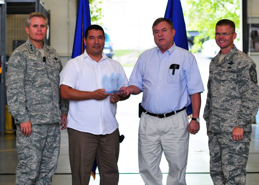 Flanked by (from left)  Lt. Gen. Eric Fiel, commander of  Air Force Special Operations Command,  and Chief Master Sgt.  William Turner, AFSOC’s command chief,  Lazaro Martin, left, and Tommy Vinson display the 919th Special Operations Wing’s Peppey Award trophy jointly presented to them during a recent quarterly awards ceremony at Duke Field, Fla.    Martin and Vinson, employed by contractor J.M. Waller Associates, Inc., are engineering support analysts and facility managers who directly support the 919th SOW. The Peppey Award is presented to selected Duke Field civilians for continuous outstanding support to the wing.  (U.S. Air Force photo/Tech. Sgt. Cheryl Foster)