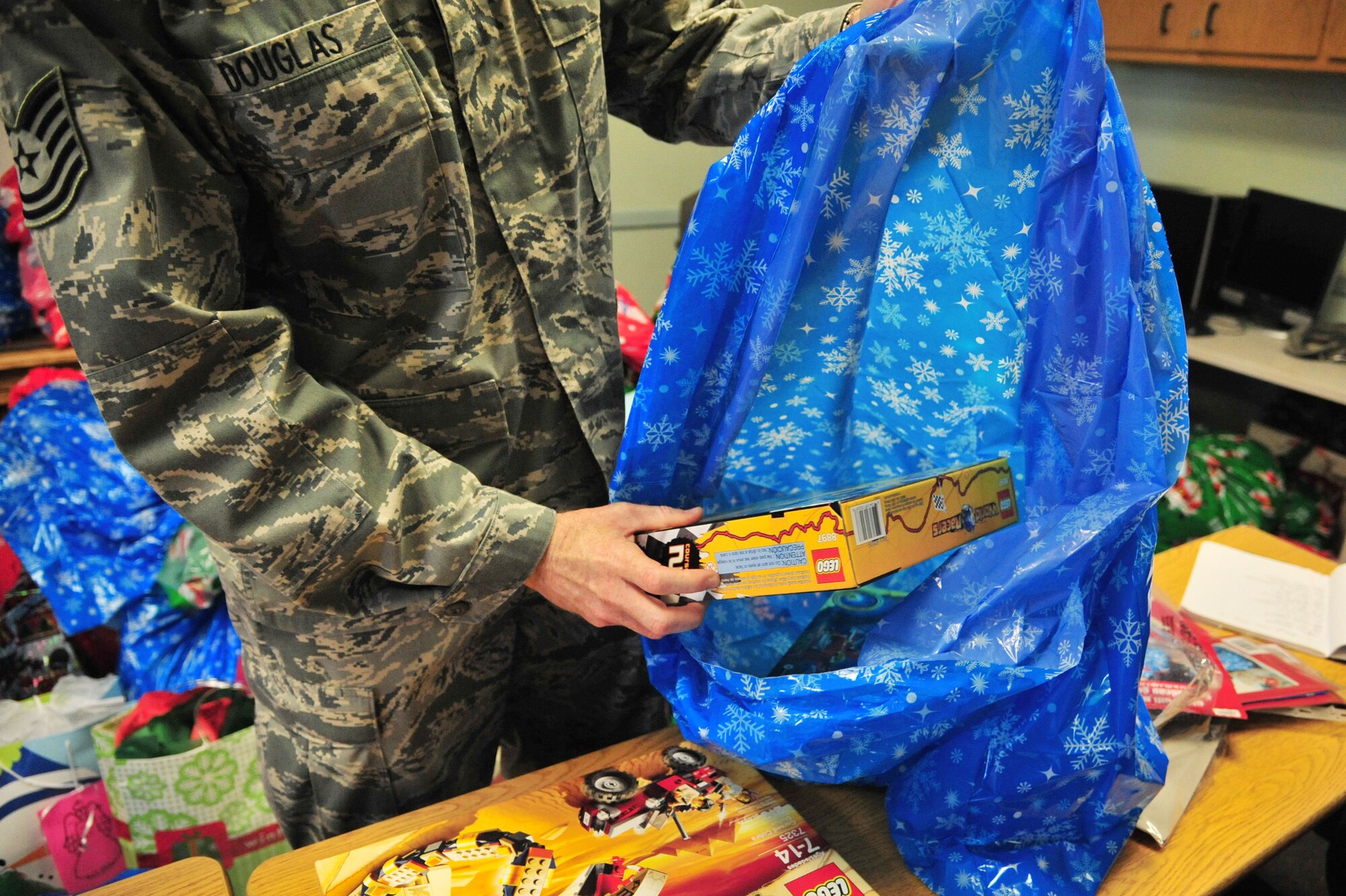 U.S. Air Force Tech. Sgt. Scott Douglas, 27th Special Operations Wing Inspector General, places gifts donated through the Angel Tree program into gift bags in the Thrift Shop at Cannon Air Force Base, N.M., Dec. 18, 2012. More than 300 gifts were provided from generous members of the wing to ensure that every child within the Cannon community has presents under their tree this year. (U.S. Air Force photo/Senior Airman Alexxis Pons Abascal) 