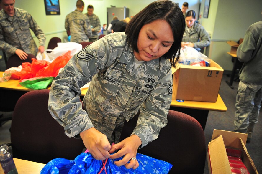 U.S. Air Force Staff Sgt. Joy Hollonquest, 27th Special Operations Wing Judge Advocate paralegal, wraps gifts donated through the Angel Tree program in the Thrift Shop at Cannon Air Force Base, N.M., Dec. 18, 2012. More than 300 gifts were provided from generous members of the wing to ensure that every child within the Cannon community has presents under their tree this year. (U.S. Air Force photo/Senior Airman Alexxis Pons Abascal) 