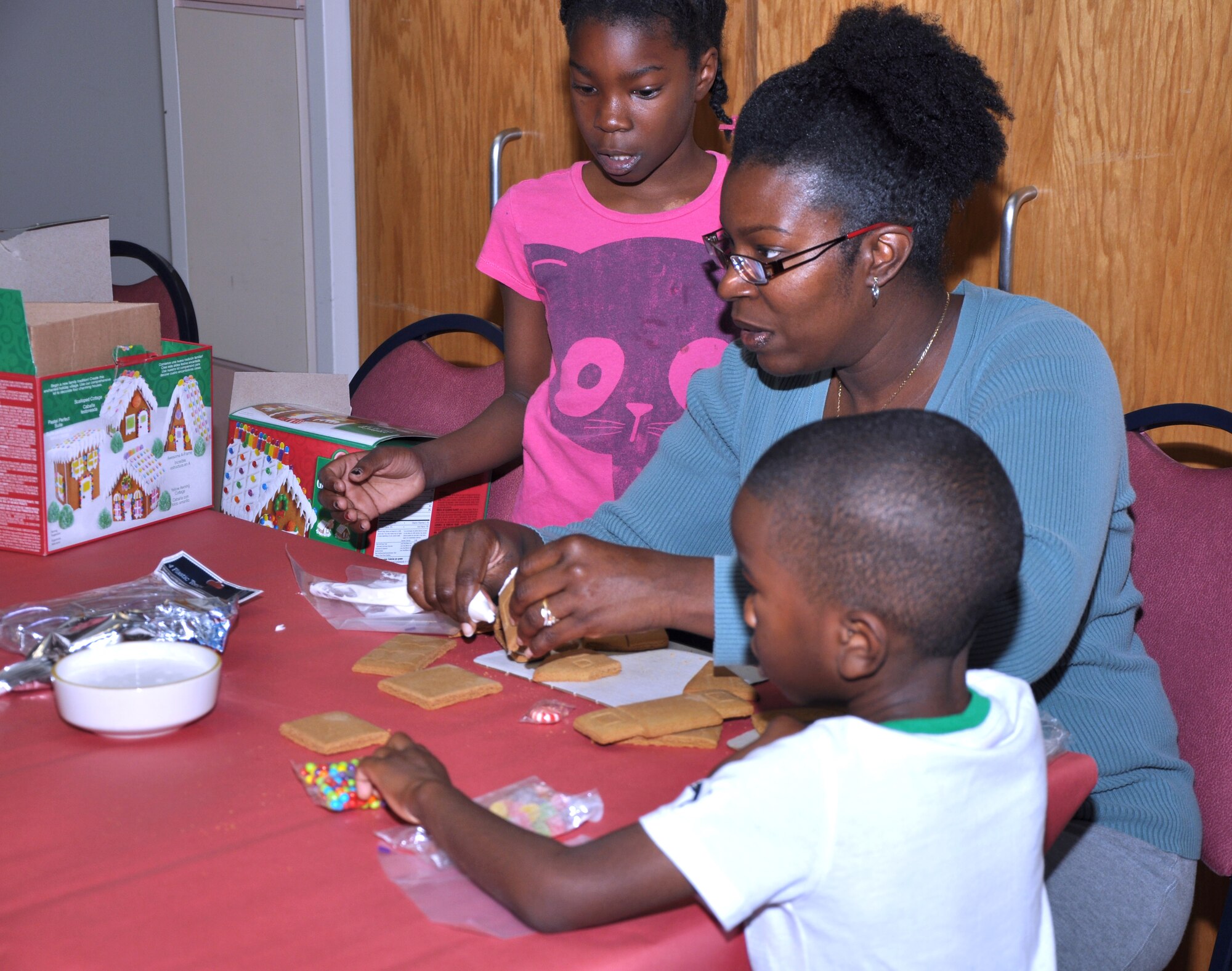 GOODFELLOW AIR FORCE BASE, Texas-- A family makes a gingerbread house at the annual Breakfast With Santa gathering for the families of deployed service members at the Event Center Dec 15. Other tables featured Christmas themed coloring pages and decorating sugar cookies. (U.S. Air Force photo/Airman 1st Class Jessica Keith) 