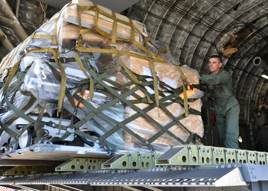 Staff Sgt. David Thomas, 315th Security Forces Squadron Raven team, helps push cargo out to the back of the C-17 during a humanitarian relief mission to St. Lucia this past weekend. The 315th Airlift Wing missions involved two C-17 Globemaster III aircraft delivering humanitarian aid, medical and school supplies, food and construction equipment valued at more than $130,000.  (U.S. Air Force Photo by Capt. Wayne Capps)