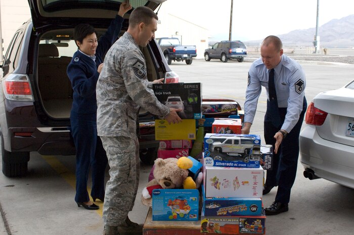 First sergeants from Nellis Air Force Base, Nev. move gifts onto a dolly to be sorted and distributed to families for Operation Warmheart Dec. 17, 2012. This is the seventh year that this program has helped needy families in the Nellis and Creech community. (U.S. Air Force photo by Airman 1st Class Monet Villacorte)