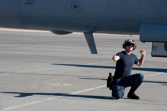 Seaman Trevor Stratton, Electronic Attack Squadron 138 plane captain, performs pre-flight checks on an EA-18G Growler during the U.S. Air Force Weapons School Mission Employment Phase Dec. 11,, 2012, at Nellis Air Force Base, Nev. The EA-18G Growler is an airborne electronic attack aircraft which operates from aircraft carriers or from land-bases. (U.S. Air Force photo by Senior Airman Matthew Lancaster)