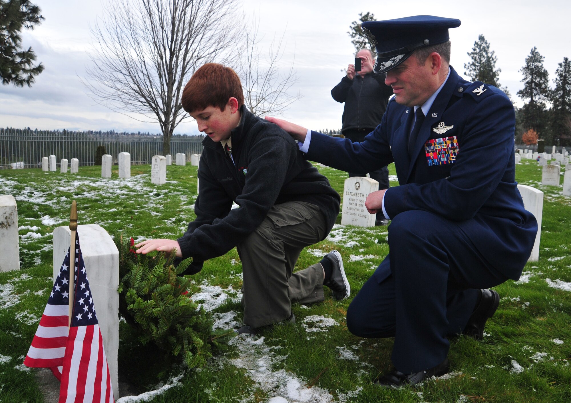 Col. Brian Newberry, 92nd Air Refueling Wing commander, and his son Matthew lay a wreath on a veteran’s headstone Dec. 15, 2012, during the Wreaths Across America event at the Fort Wright Cemetery in Spokane, Wash. This marks the first year that Wreaths Across America was held at the cemetery. (U.S. Air Force photo by Airman 1st Class Taylor Curry)