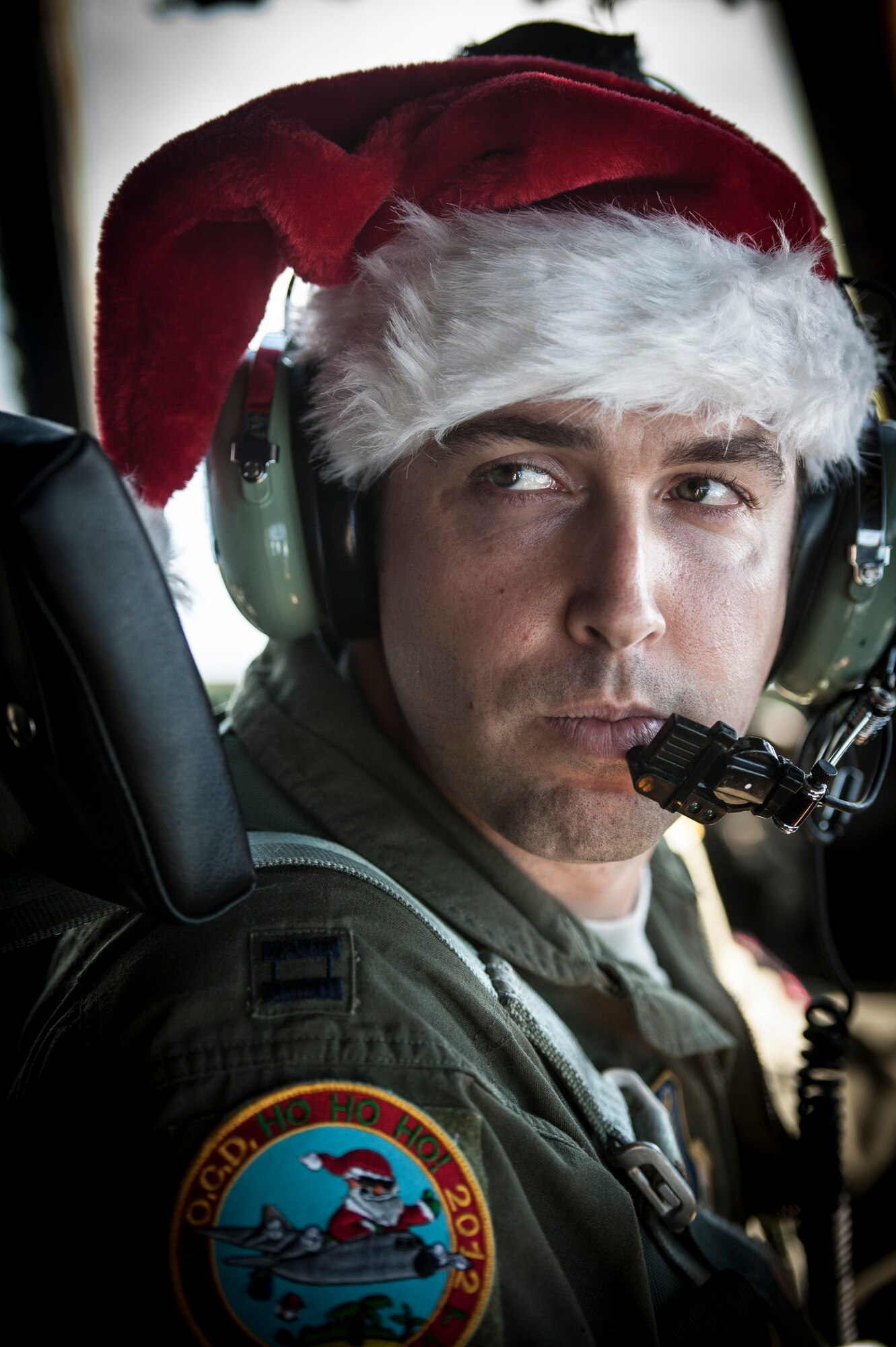 OVER THE PACIFIC OCEAN -- Capt. Dereck Monnier, 36th Airlift Squadron pilot and aircraft commander, looks at a fellow crew member during a flight over Micronesia Dec. 18, 2012. Monnier wore a Santa hat because the flight was part of Operation Christmas Drop, a 61-year-old humanitarian airlift mission carrying donated supplies to remote islands in Micronesia. (U.S. Air Force photo by Tech. Sgt. Samuel Morse)
