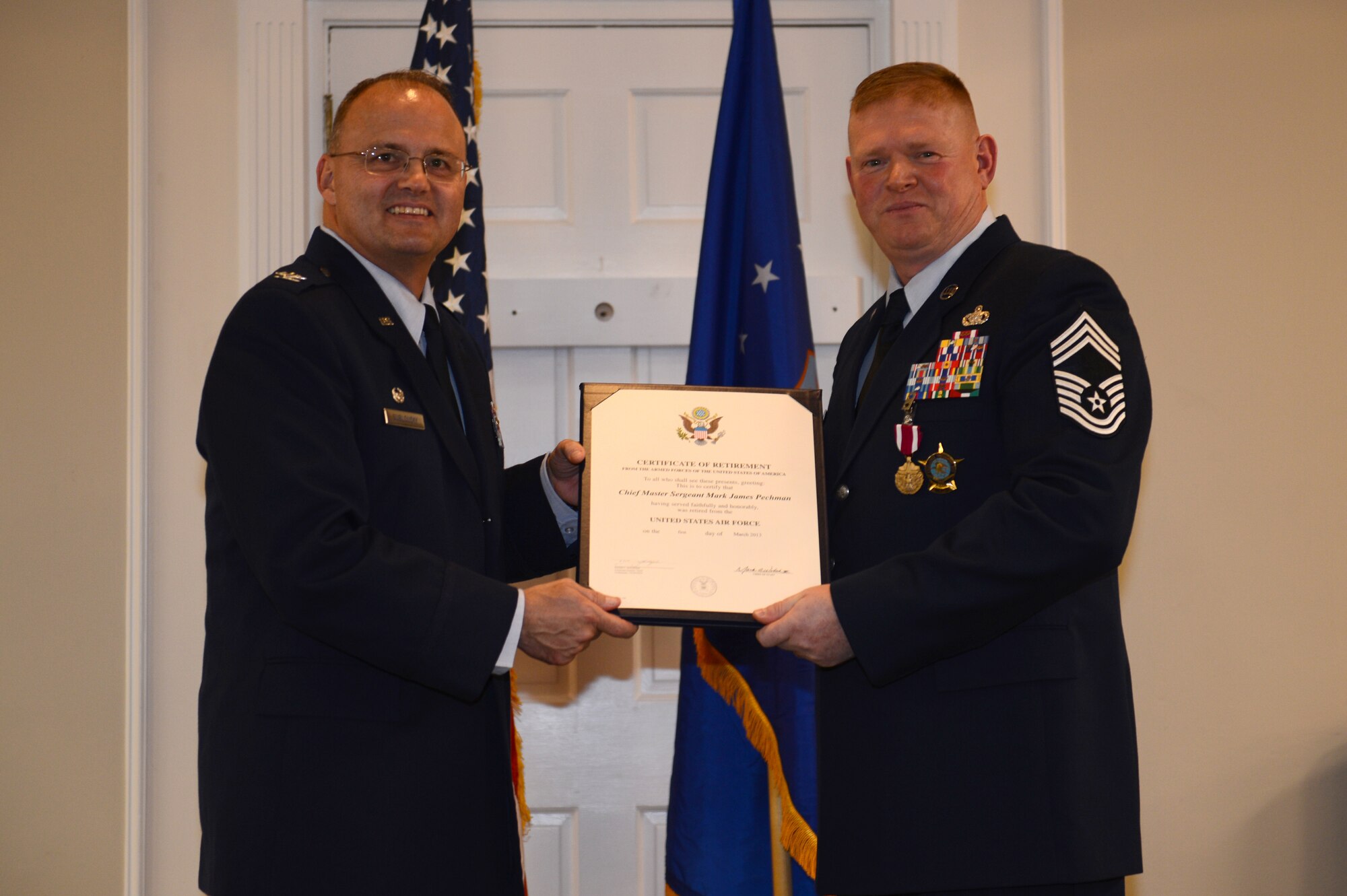 Col. Joseph Sublousky, U.S. Air Forces Central Command director of communications, presents Chief Master Sgt. Mark Pechman, AFCENT postal chief enlisted manager, with his certificate of retirement at Carolina Skies Club and Conference Center, S.C. Dec. 12, 2012. Pechman is a native of Iowa City, Iowa, and he joined the Air Force in 1984. (U.S. Air Force photo by Airman 1st Class Krystal Jeffers/Released)