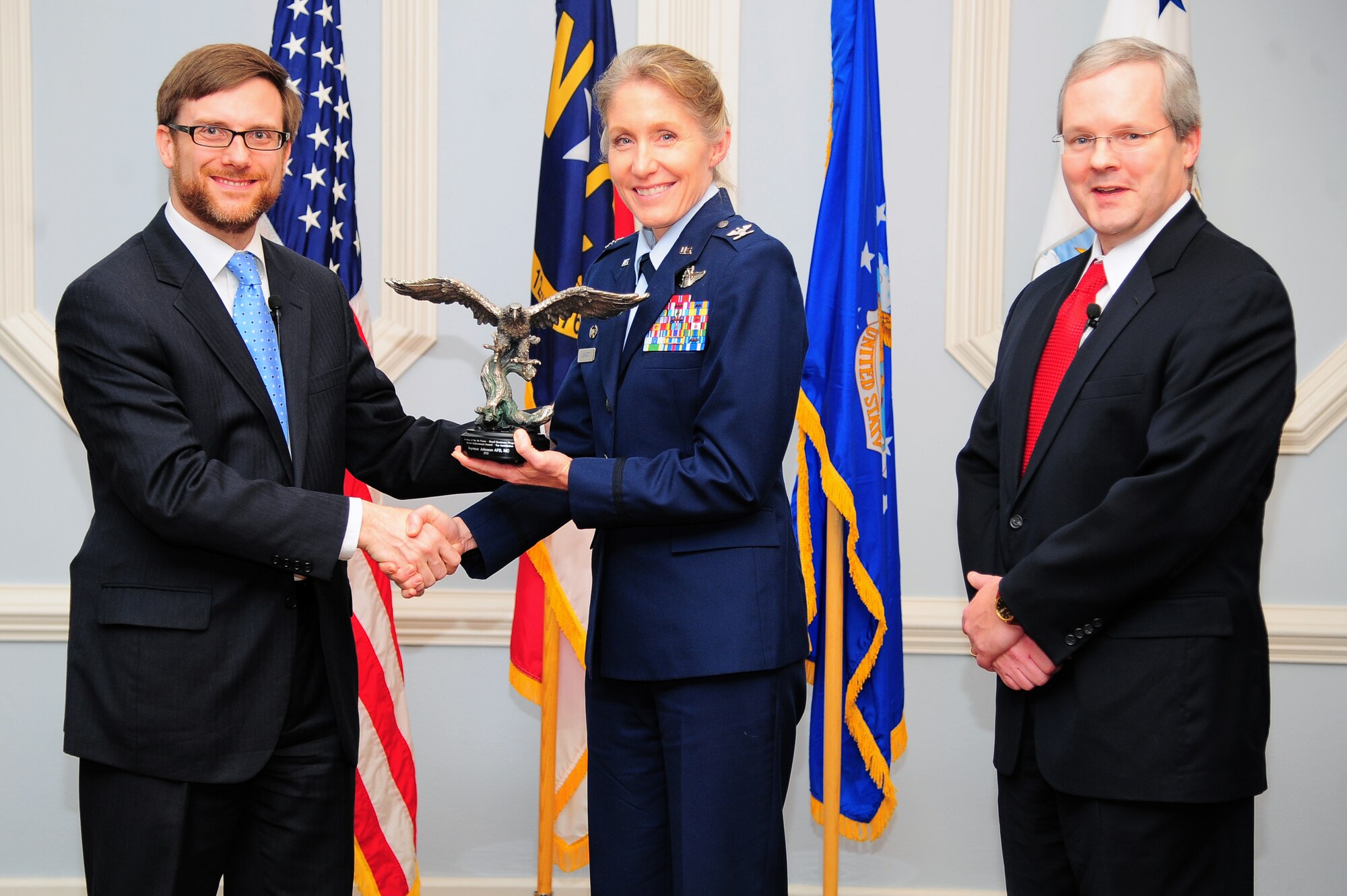 Acting Under Secretary of the Air Force Dr. Jamie Morin, and Joseph McDade, director of the Air Force Office of Small Business Programs, recognize Col. Jeannie Leavitt, 4th Fighter Wing commander, during a small business awards ceremony on Seymour Johnson Air Force Base, N.C., Dec. 17, 2012.  On behalf of the wing, Leavitt received the 2012 Air Force Top Installation for Small Business award. The wing was recognized for its superior achievements, leading the Air Force with an unprecedented 96 percent contracting rate with small business. (U.S. Air Force photo/Airman 1st Class Aubrey White/Released)