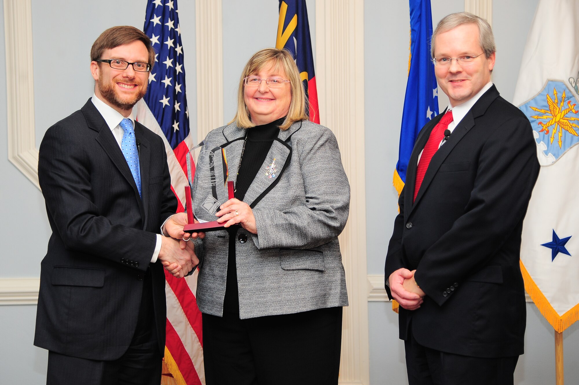 Acting Under Secretary of the Air Force Dr. Jamie Morin, and Joseph McDade, director of the Air Force Office of Small Business Programs, recognize Becky Carpenter, Air Combat Command director of small business, during a small business awards ceremony on Seymour Johnson Air Force Base, N.C., Dec. 17, 2012. Carpenter received the 2012 Major Command Small Business Director’s award due to her efforts to enable ACC to award more than 57 percent of their prime contracts to small businesses. (U.S. Air Force photo/Airman 1st Class Aubrey White/Released)
