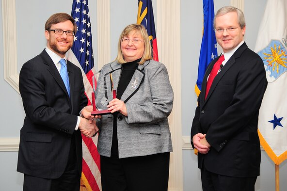 Acting Under Secretary of the Air Force Dr. Jamie Morin, and Joseph McDade, director of the Air Force Office of Small Business Programs, recognize Becky Carpenter, Air Combat Command director of small business, during a small business awards ceremony on Seymour Johnson Air Force Base, N.C., Dec. 17, 2012. Carpenter received the 2012 Major Command Small Business Director’s award due to her efforts to enable ACC to award more than 57 percent of their prime contracts to small businesses. (U.S. Air Force photo/Airman 1st Class Aubrey White/Released)