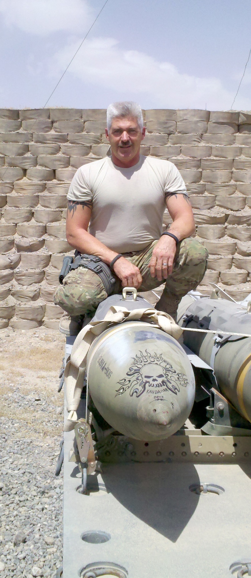 SOUTHWEST ASIA – Senior Master Sgt. Steven Hadley, a vehicle operations superintendent with the 927th Air Refueling Wing, poses with a 500-pound bomb while deployed in Southwest Asia. Hadley was the only reservist in his unit and effectively managed more than 900 vehicles at numerous forward operating bases.  (Photo courtesy of Senior Master Sgt. Steven Hadley)