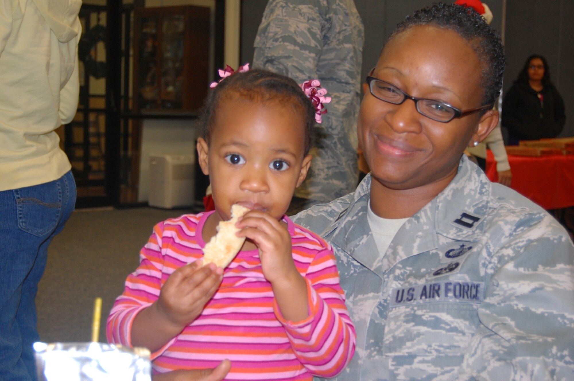 Addison Smith takes a break from the USAFCENT Children's holiday
party December 13 at Shaw AFB, S.C. to eat some pizza with her mother,
Captain Latoya Smith, USAFCENT FM. (U.S. Air Force photo by USAFCENT Public Affairs/Released)
