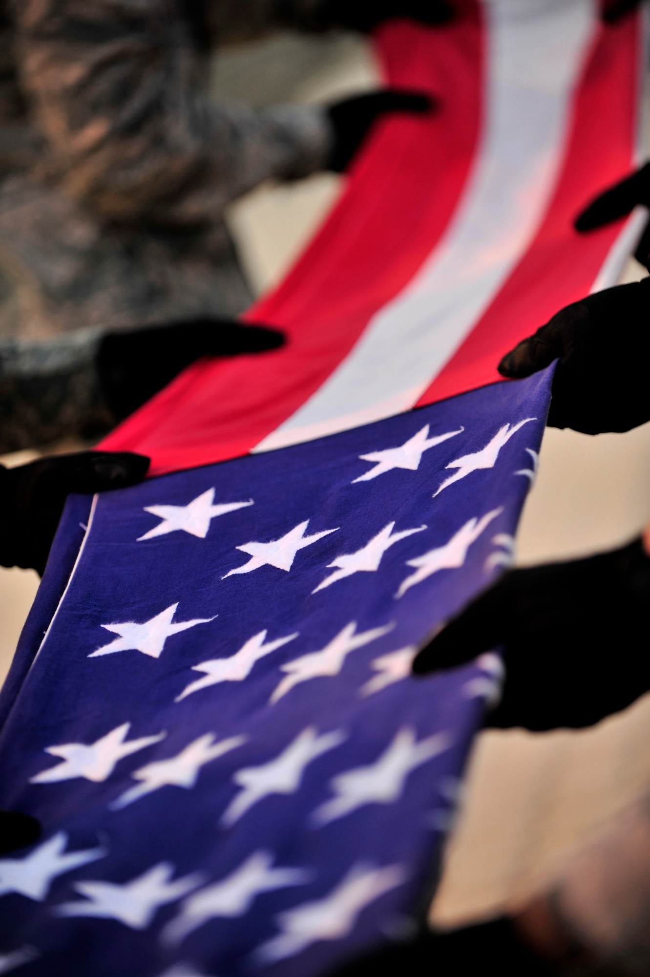 SOUTHWEST ASIA -- Members of the 380th Air Expeditionary Wing Honor Guard fold the flag Nov. 30, 2012, during the monthly retreat ceremony. In addition to their regular 12-hour, six-day-a-week work schedule, base honor guard members voluntarily devote more than fours a week to practice and details. (U.S. Air Force photo/Tech. Sgt. Christina M. Styer) (RELEASED)