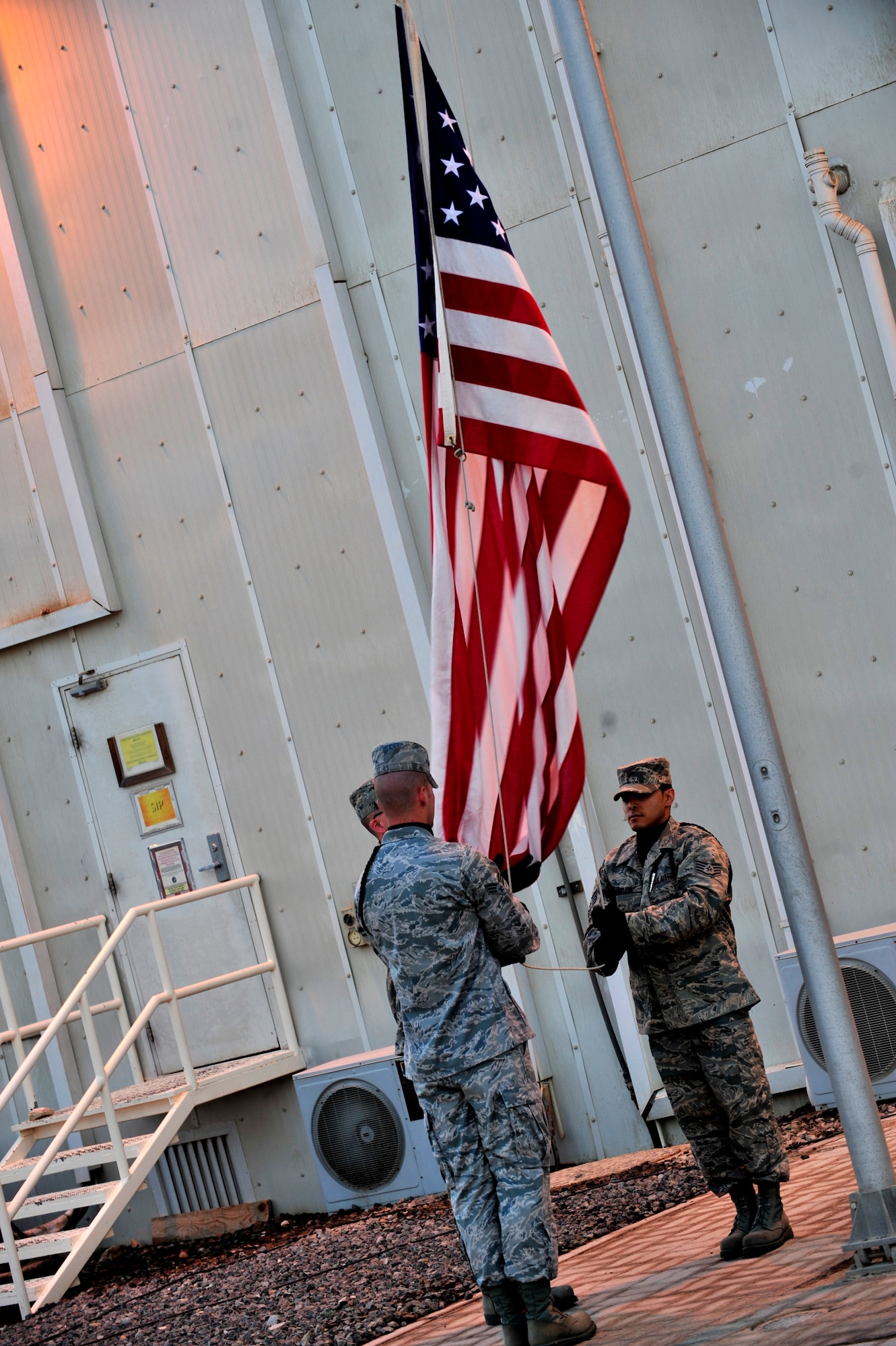 SOUTHWEST ASIA -- U.S. Air Force Airman 1st Class Phillip Campbell, Senior Airman Wilbert Werner and Staff Sgt. Israel Santiago, 380th Air Expeditionary Wing honor guard members, lower the colors during a retreat ceremony Nov. 30, 2012. The wing performs a unique monthly retreat ceremony to honor the month's fallen Airmen. (U.S. Air Force photo/Tech. Sgt. Christina M. Styer) (RELEASED)