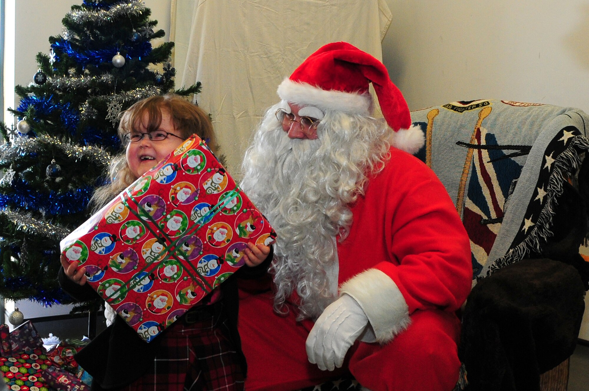 DUXFORD IMPERIAL WAR MUSEUM, England – Savannah Owen, 5, receives a present from Santa Claus, a North Pole native, during a children’s Christmas party at the Duxford Imperial War Museum Dec. 15, 2012. The 492nd Fighter Squadron hosted this year’s annual children’s Christmas party, which was attended by more than 40 children including many from U.K. hospitals. (U.S. Air Force photo by Airman 1st Class Cory D. Payne)