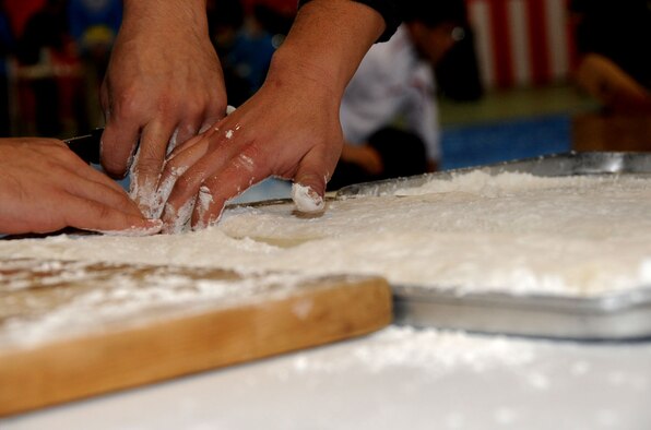 Ceremony workers slice fresh mochi, a type of traditional Japanese rice cake, during the annual mochi-pounding ceremony at the Japan Air Self-Defense Force gym at Misawa Air Base, Japan, Dec. 14, 2012. American and Japanese participants worked together to pound the rice into the traditional Japanese treat. (U.S. Air Force photo/Airman 1st Class Kenna Jackson) 
